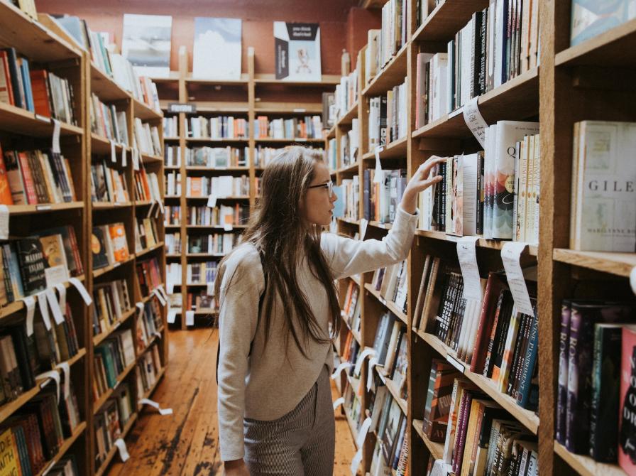 Ung kvinde på bibliotek